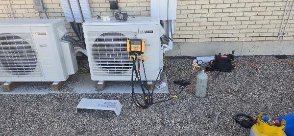 Heat pump service with gauges on a roof